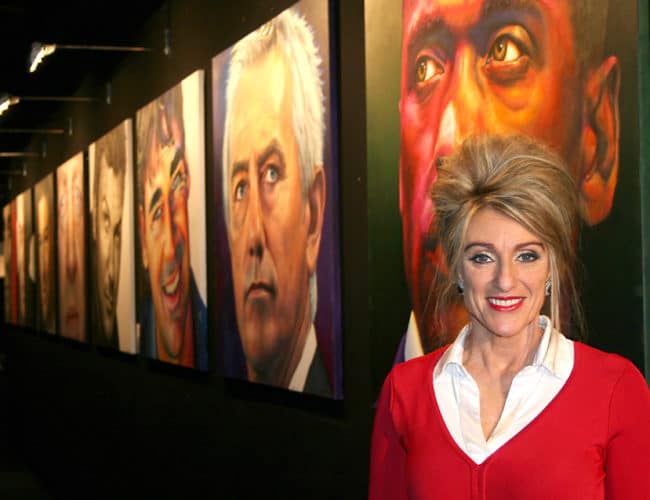 Saskia poseert met haar portretten tijdens de excellent beurs in de stand van 'The art of living well'